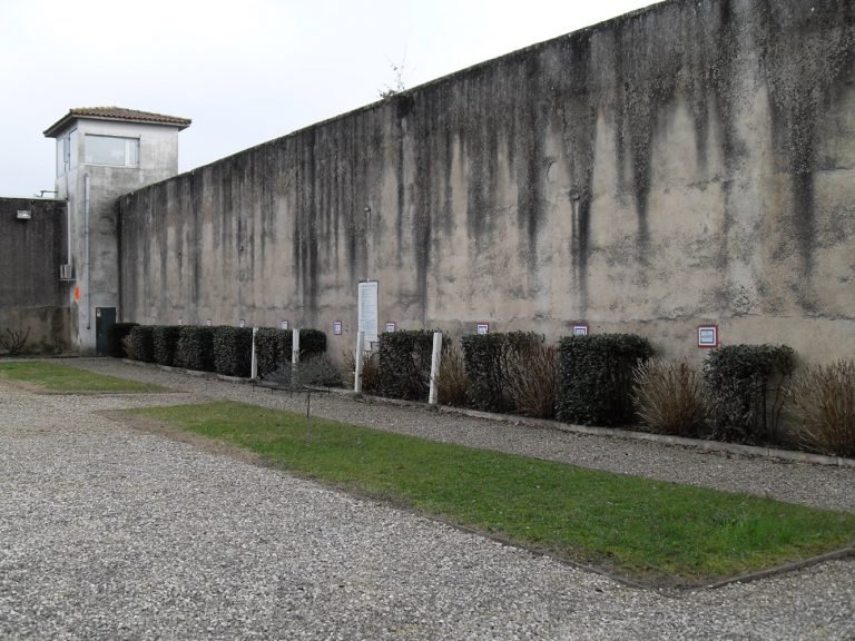 Frente a este muro, doce resistentes, considerados como los líderes del intento de fuga colectiva del 19 de febrero de 1944, fueron fusilados el 23 de febrero de 1944. Doce placas de mármol colocadas en la pared recuerdan sus nombres. (AERI)